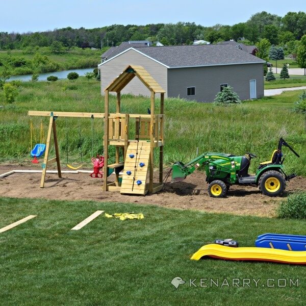 Using a tractor to level the place for a sandbox next to a playset. 