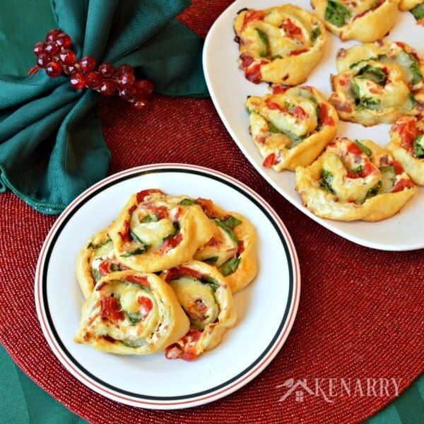 Great finger food for a Christmas cocktail party! Bacon Spinach Blossoms with roasted red peppers and Italian cheeses are an easy festive holiday appetizer recipe. These pinwheel bites will be gone in no time! #appetizer #partyfood #kenarry