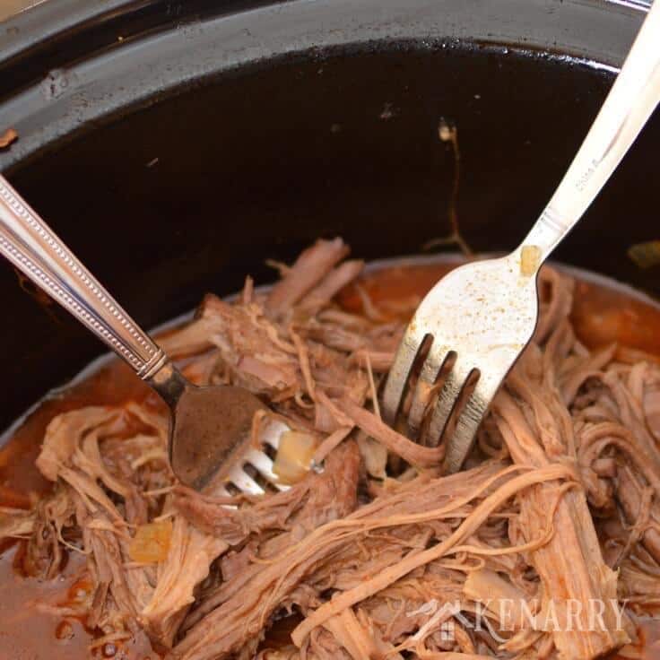 Shredded slow cooked beef roast with two forks. 