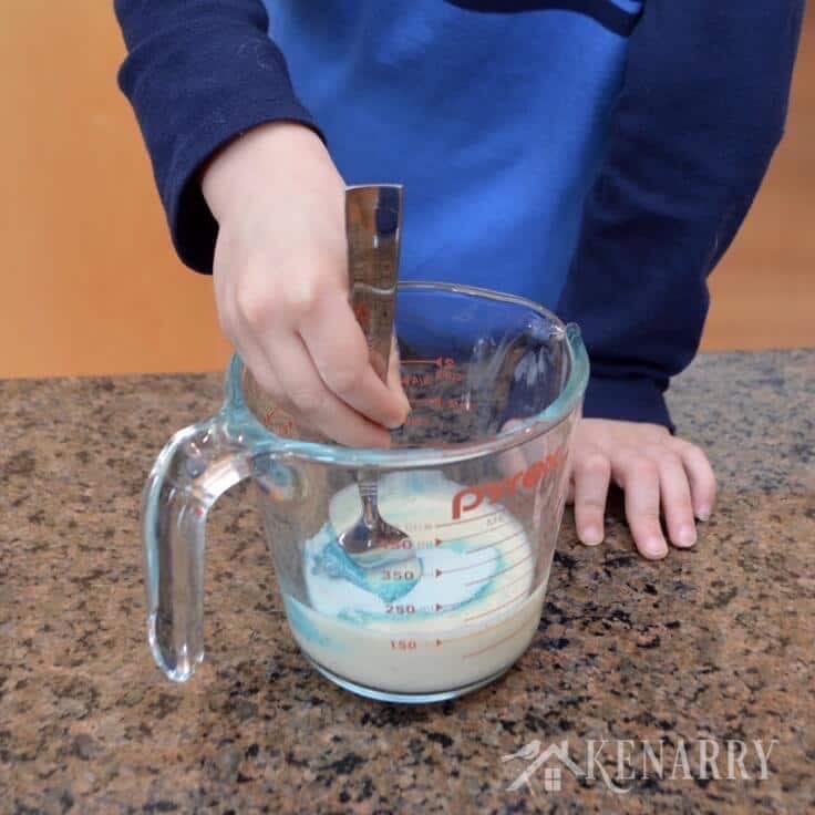 A little boy stirs pudding mix 