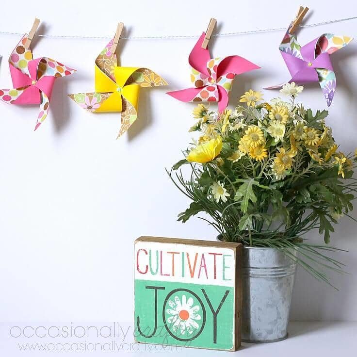 A colorful DIY pinwheel banner hanging up on the wall. 