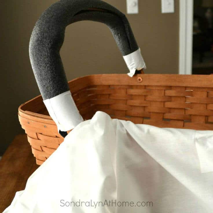 Wrapping a basket's handle with a pool noodle to make a bassinet centerpiece