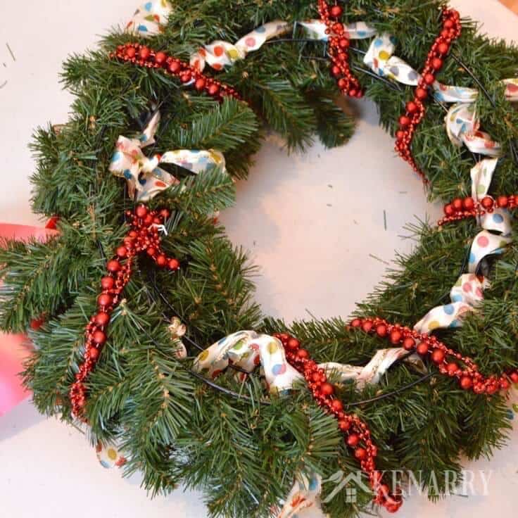 Love this idea to decorate an outdoor Christmas wreath with ribbon, beads and ornaments. Beautiful holiday home decor for your front door! - Kenarry.com