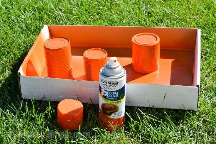 Orange spray paint on empty tin cans. 