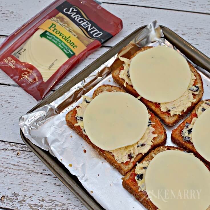 Cheese slices on top of slices of wheat bread with chicken and red pepper jelly