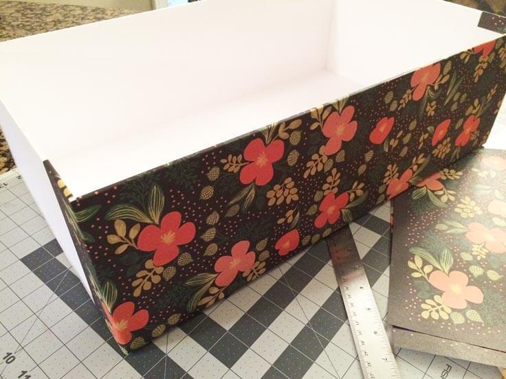 Attaching decorative paper to the outside of the DIY storage boxes 