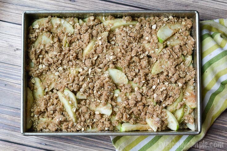 apples with old fashioned oats crumble in a 9x13 pan before it goes into the oven to make apple crisp
