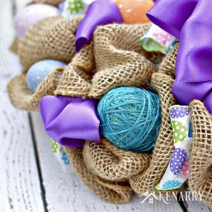 What a pretty craft idea for an Easter wreath! The burlap ribbon gives it a rustic look -- and the Easter eggs and bright purple accents make it look so fun and festive to decorate my home for spring.