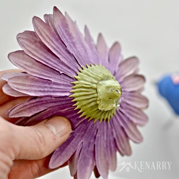 A purple artificial flower with hot glue on the back. 