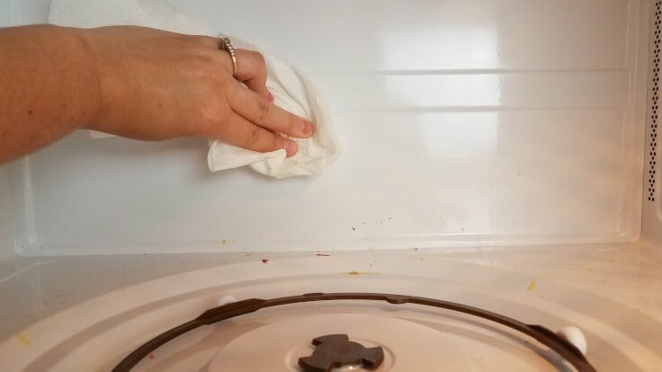 Wiping down the inside of a dirty microwave