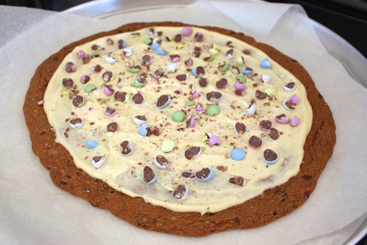 a pizza sized chocolate chip cookie decorated with Cadbury mini eggs for Easter