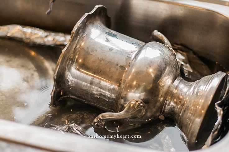 A silver dish sits in the sink in the DIY silver cleaner. 
