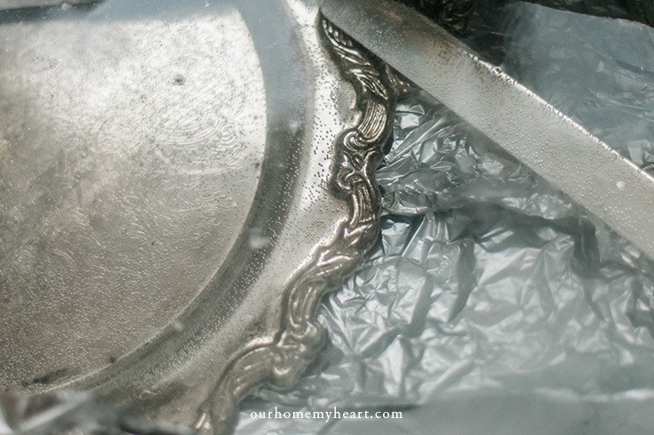 Washing a silver platter with DIY silver cleaner. 