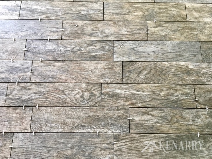 The Marazzi Montagna Rustic Bay 6 in. x 24 in. Glazed Porcelain Floor Tiles used in this cottage update look like weathered wood. This flooring gives the sunroom a rustic farmhouse style look.