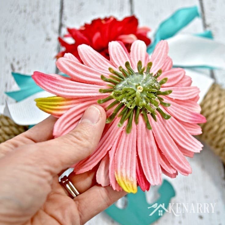 Hot gluing artificial flowers on a wreath