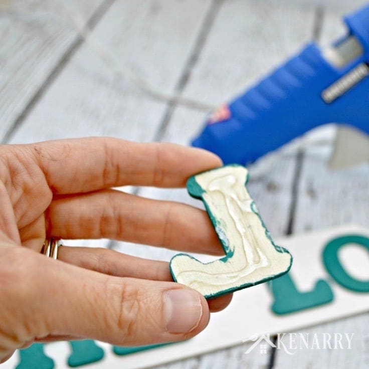 Gluing the letters to spell Hello to a wreath 