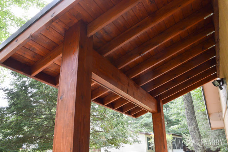 Cedar wood posts and ceiling are perfect for this large craftsman style front porch created for an A-frame cottage home | river rock pillars | outdoor patio | home idea