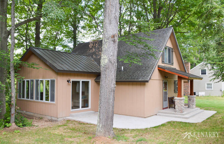 A sunroom and front porch were added to this a-frame cottage on a wilderness river to give the home a beautiful craftsman style look | river rock pillars | exposed aggregate concrete | home idea | stained cedar wood | concrete patio