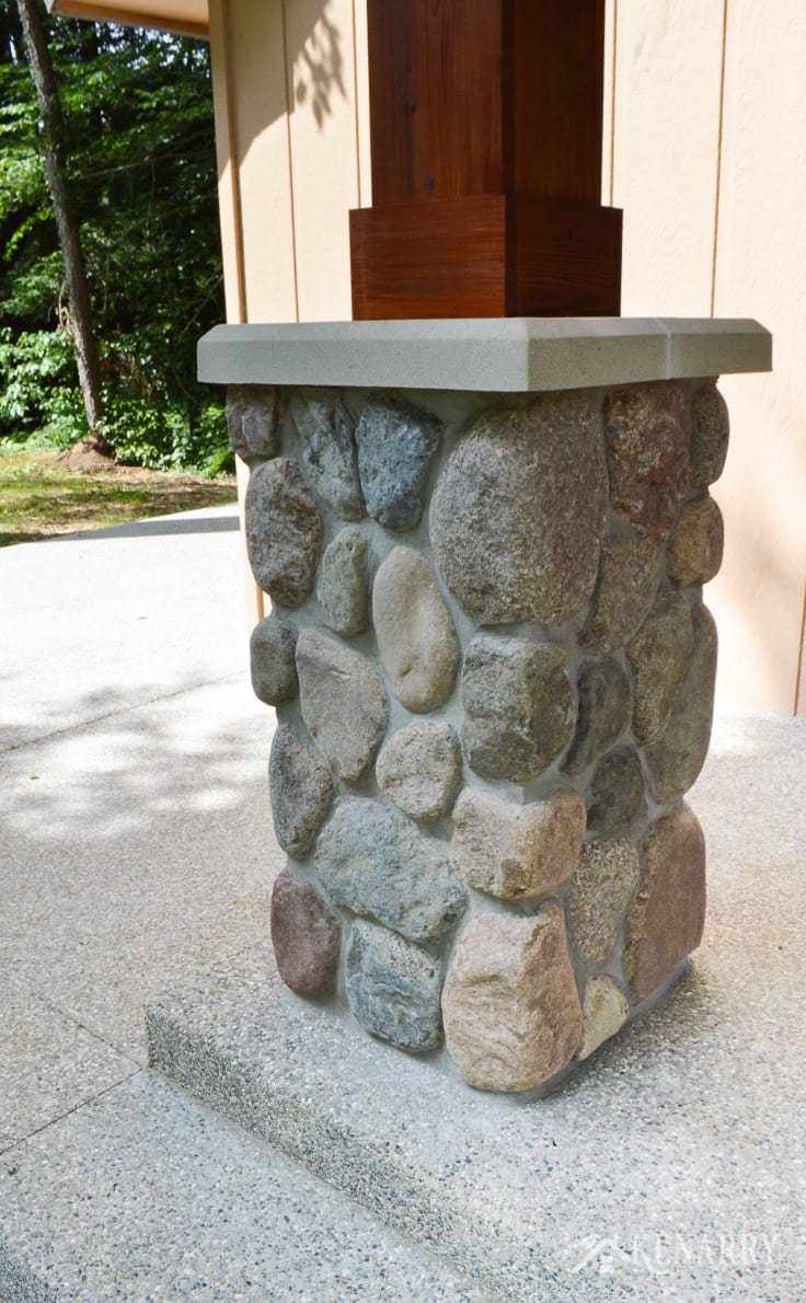 River rock pillars hold up cedar posts for this craftsman style porch on the front of an a-frame cottage | home idea | stone pillar | exposed aggregate concrete