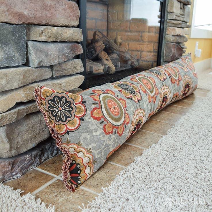 Turn an old body pillow into a fireplace draft stopper. This easy sewing tutorial is perfect for beginners. Plus a DIY draft blocker will help to save heating costs and block cold air this winter. draft stopper | draft protector | draft excluder | door draft blocker