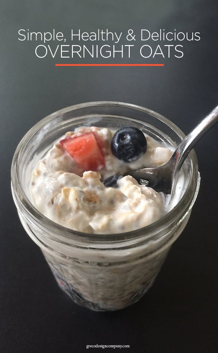 overnight oats in a mason jar topped with strawberries and blueberries with a spoon