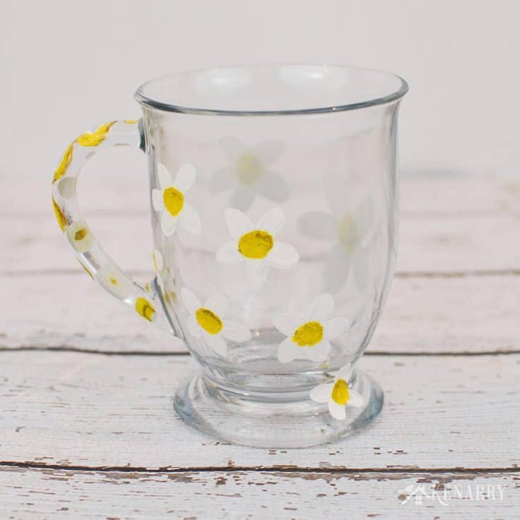 I love the simple daisy pattern on the side of this coffee cup. Learn how to paint DIY coffee mugs in this easy craft tutorial.