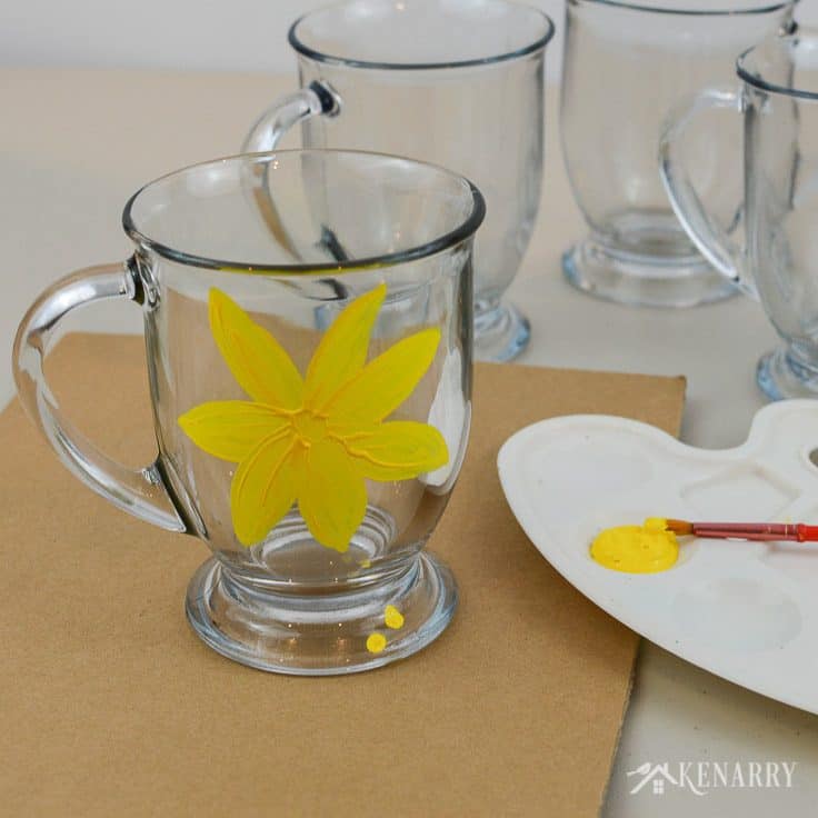 Use yellow gloss enamel craft paint to create a floral design on DIY coffee mugs. What a fun and easy craft idea!