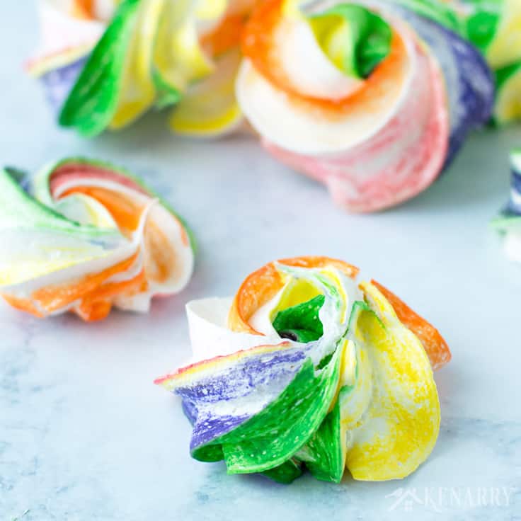 rainbow meringue cookies on a marble surface