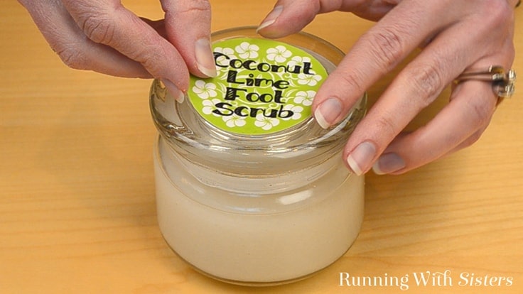 Adding the coconut lime foot scrub label to the jar of foot scrub. 