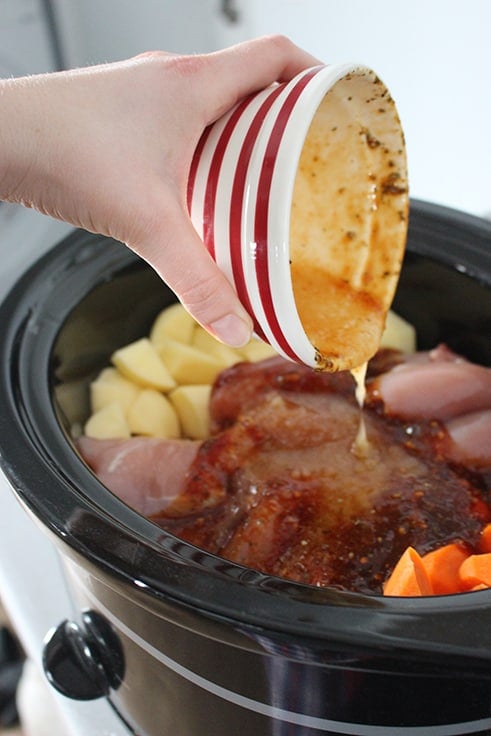 pouring sauce onto Slow Cooker Honey Garlic Chicken and Vegetables