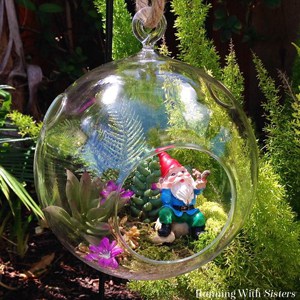 Create a succulent bubble garden with faux succulents and little garden gnome. The glass orb makes this bubble terrarium extra cute! 