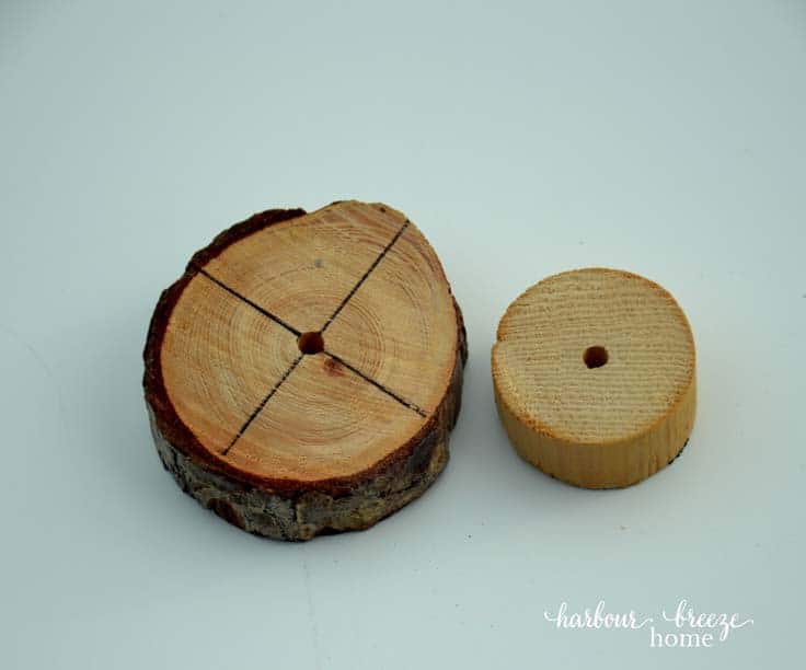 a wood slice from a branch with and a wooden dowel with holes drilled in the center of each