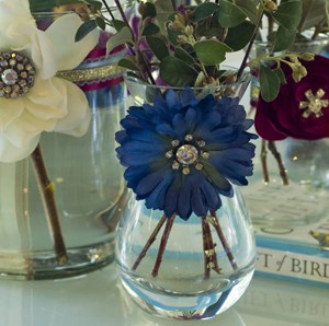 Dress up dollar store vases with playful flowers and brooches. This is an easy and cheap decorating idea!