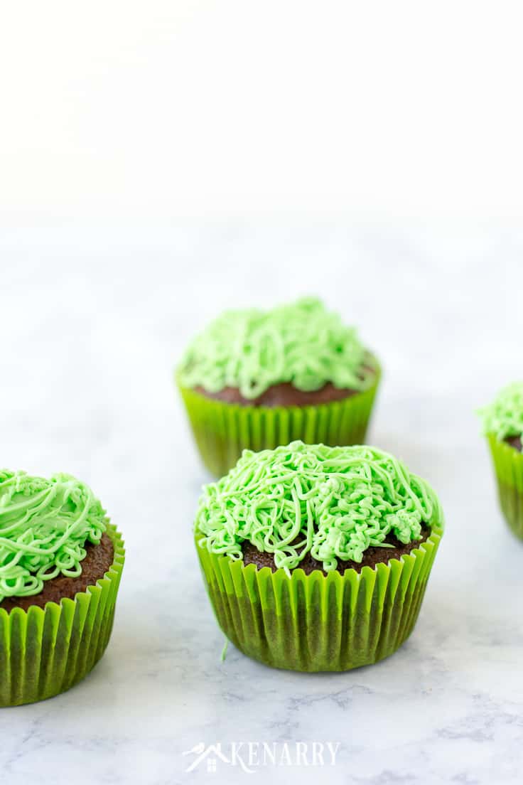 Top cupcakes with green frosting to look like grass, then decorate each of them with a lawn mower made of candy. Dad will love this fun idea for Father's Day cupcakes. #fathersday #cupcakes