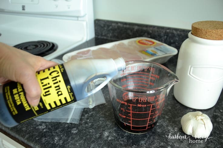 soy sauce being poured into measuring cup