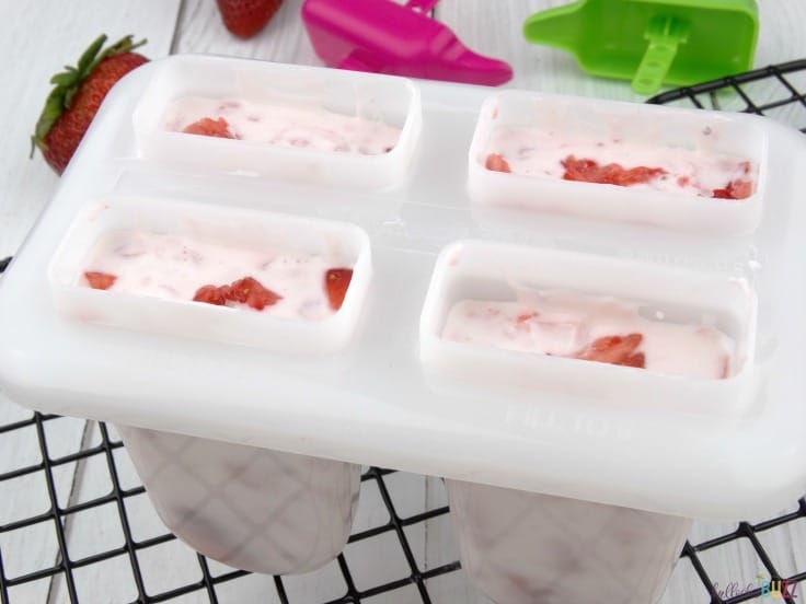 Strawberry Vanilla Yogurt Popsicles fill popsicle molds