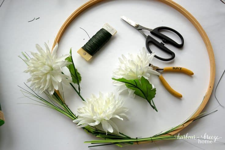 Attach flowers one at a time to an embroidery hoop wreath