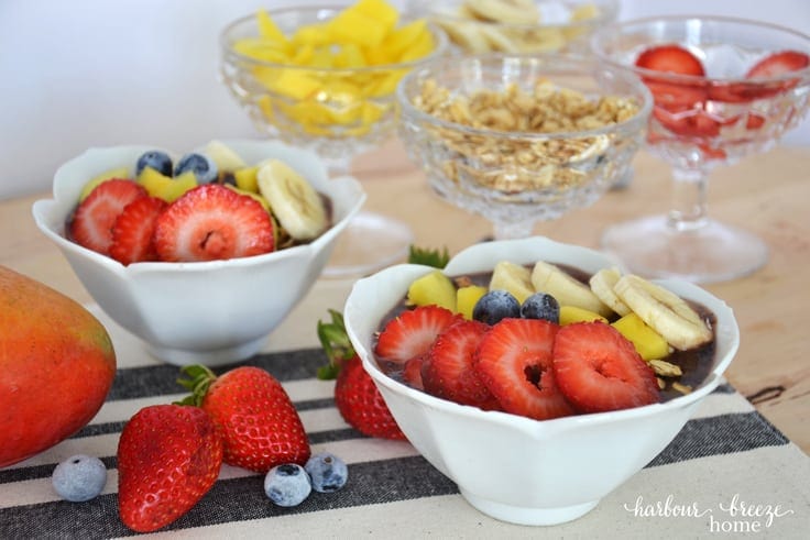 Front view of açaí berry bowls topped with fresh fruit and granola