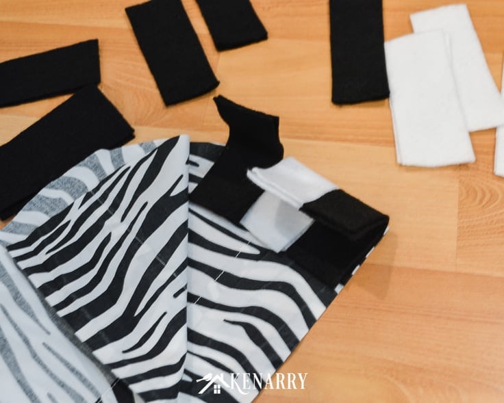 Black and white felt and zebra striped fabric make up this easy zebra costume to make for a child to wear for Halloween or every day dress up.