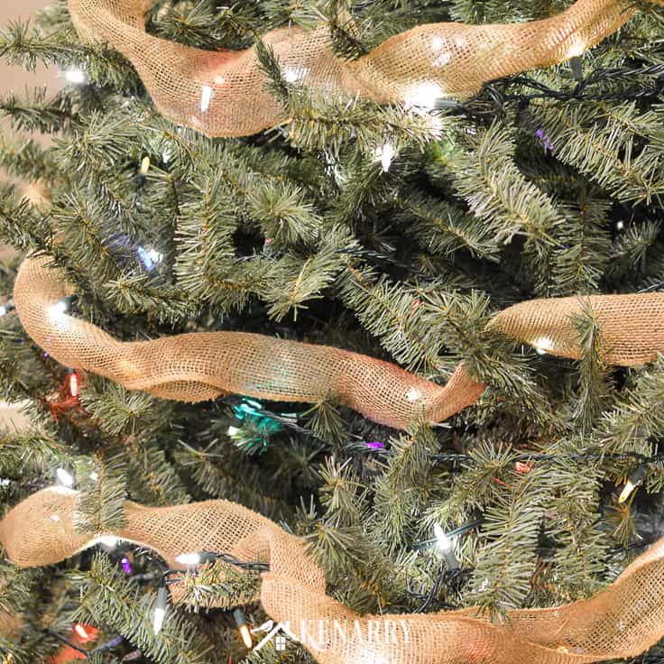 Love farmhouse style decor? Learn how to decorate a rustic Christmas tree like a professional this holiday season with ornaments, lights, and wide burlap ribbon as garland using these step by step instructions. #christmastree #christmas #kenarry