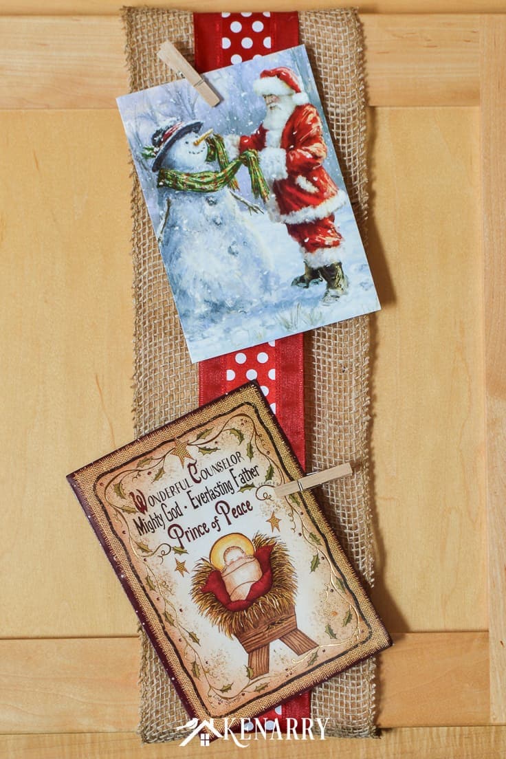 Use wide ribbon, burlap and small clothes pins for displaying Christmas cards on your kitchen cabinets so you can enjoy looking at them throughout the holidays. It's a super easy DIY idea to display your cards for the season! #christmascards #christmas #kenarry
