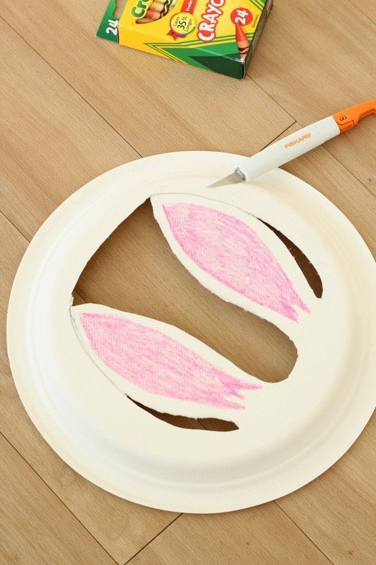 Cutting out paper plate bunny ears with detail knife.