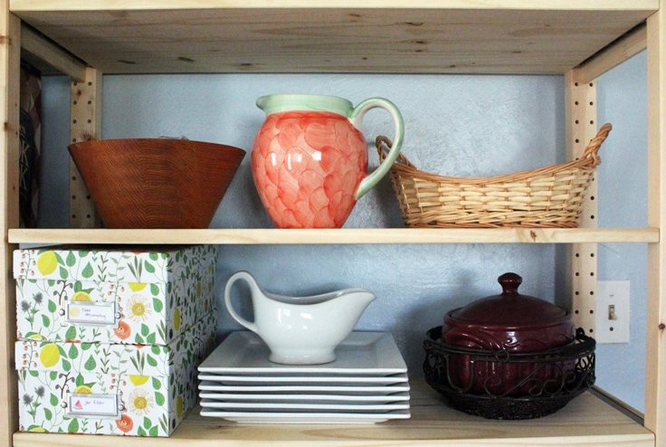  Using open shelving can be pretty and practical for kitchen organizing. All you need are a few photo boxes and some printable labels to not only hide the clutter but make it easy to find when you need it. 