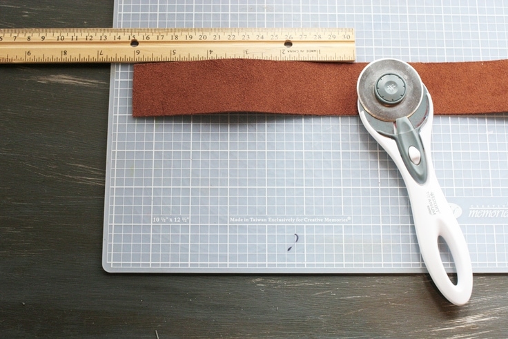 Cut the leather for a personalized leather keychain with a rotary cutter.