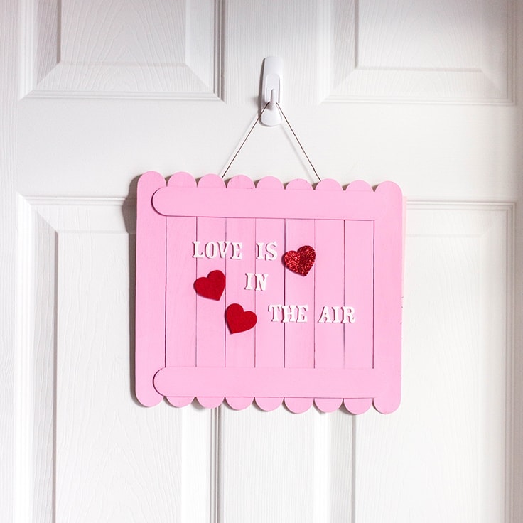 Show 'em that you care with this super easy DIY Valentine's Day wall sign. It's a beautiful Valenine's craft for kids and adults. C'mon! It's time to spruce-up your home for the most romantic time of the year! #valentines #valentinecrafts #kenarry