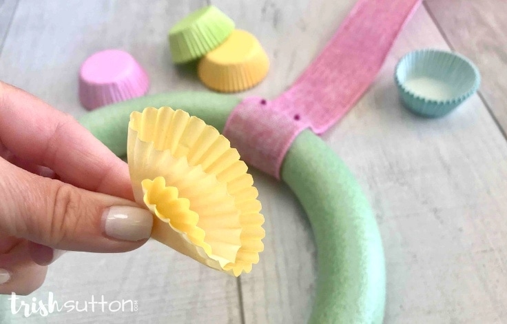 How to fold cupcake liners to in the shape of flowers for a spring wreath. 