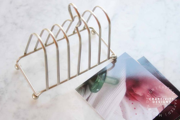 Photos on a marble countertop next to a gold file holder. 