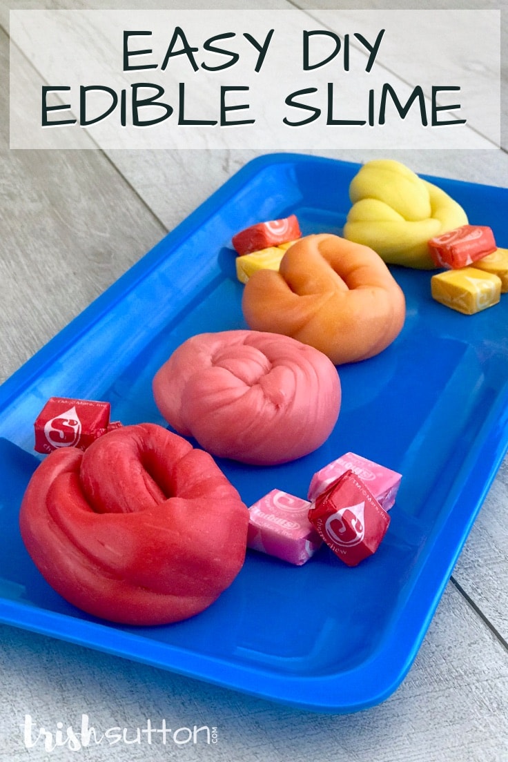 Red, pink, orange and yellow Starburst slime sitting on a bright blue tray with candy pieces. Photo reads: Easy DIY Edible Slime