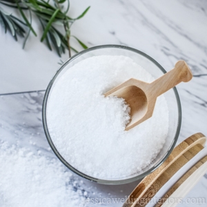 image of a glass jar of quick and easy homemade bath salts with a wooden scoop and lid