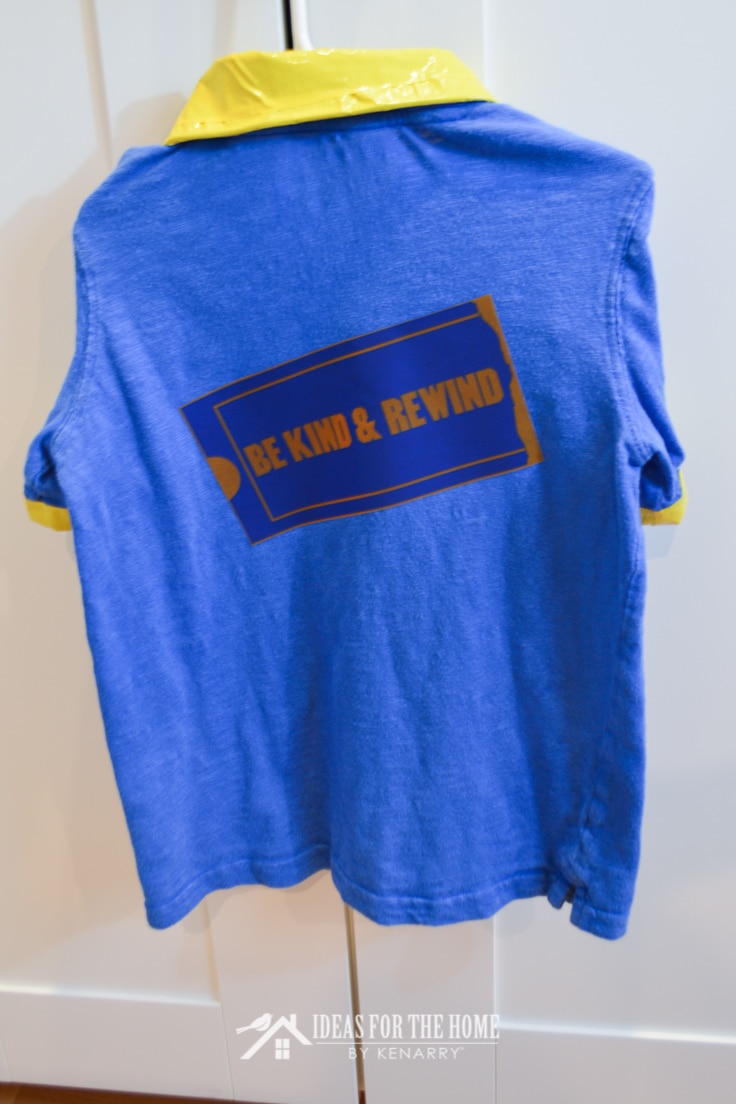 A blue Blockbuster Video shirt on a hanger with the saying "Be Kind & Rewind" on the back of it.
